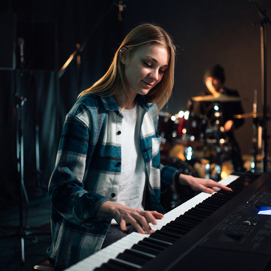 A girl playing the synthesizer music creation in a studio