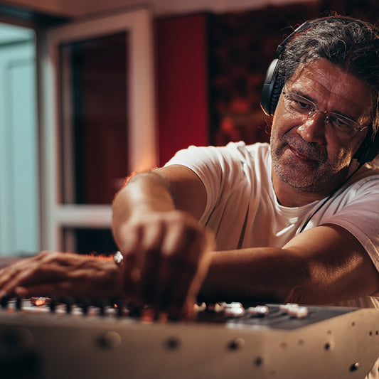 senior hispanic music producer working on a mixing studio