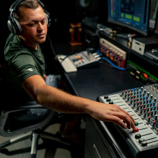 a focused male sound engineer wearing headphones