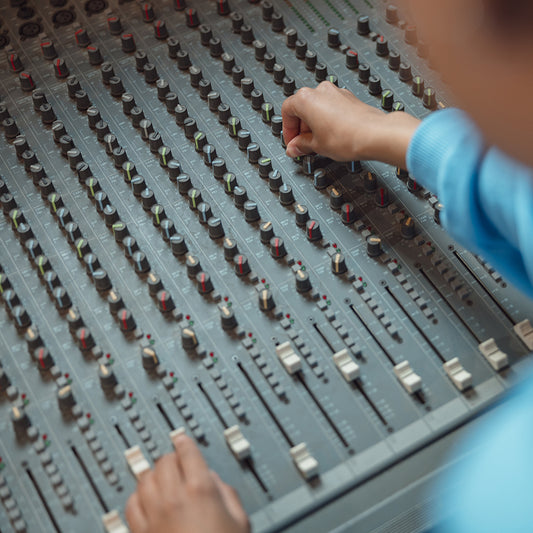 producer working in sound recording studio uses mixing console