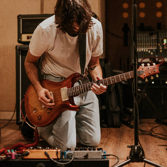Guitarist plyaing in pracrice room