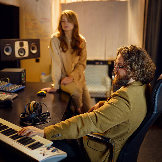 Sound engineer and music producer talking in professional recording studio