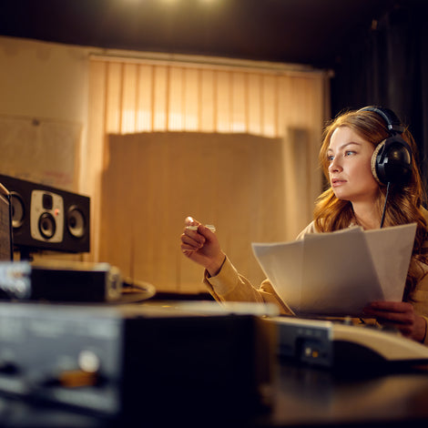 Femail engineer in headphones recording studio