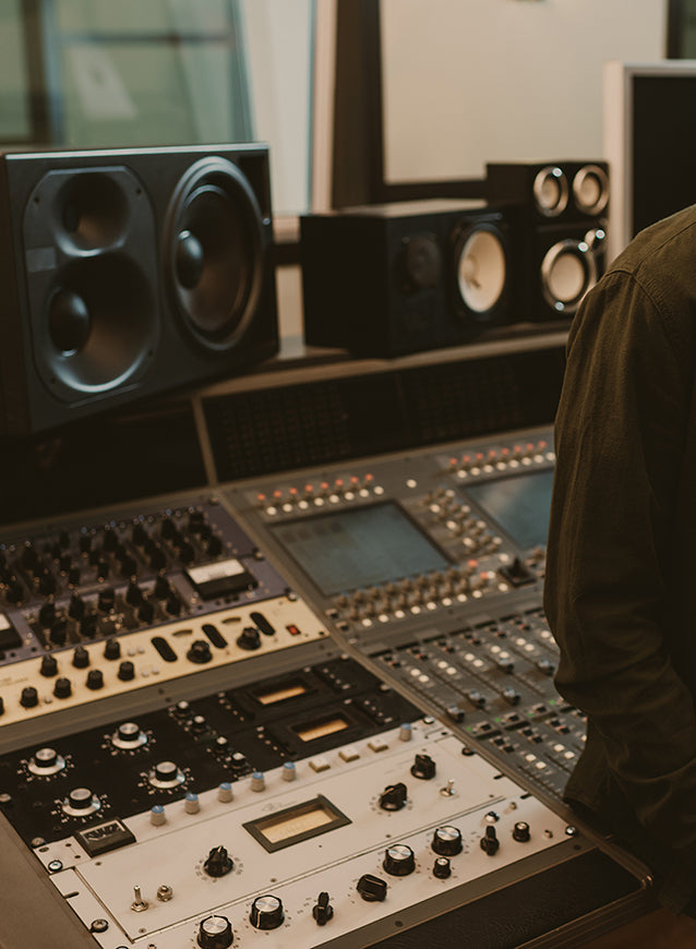 Sound producer in headphones leaning back on recording studio mobile