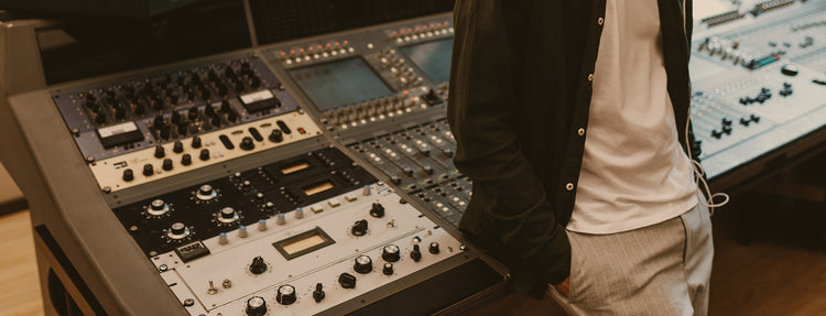 Sound producer in headphones leaning back on recording studio